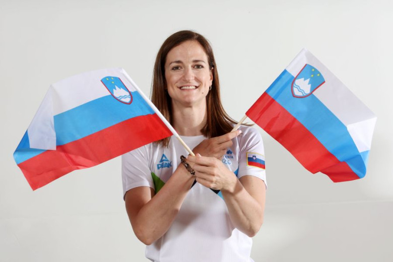 A woman is holding two Slovenian little flags in hands