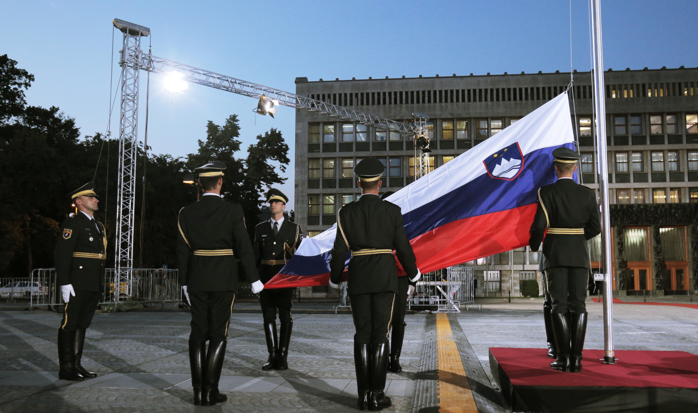 Members of a ceremonial guard take part in raising the Slovenian flag on a flagpole at Republic Square in front of the parliament building.