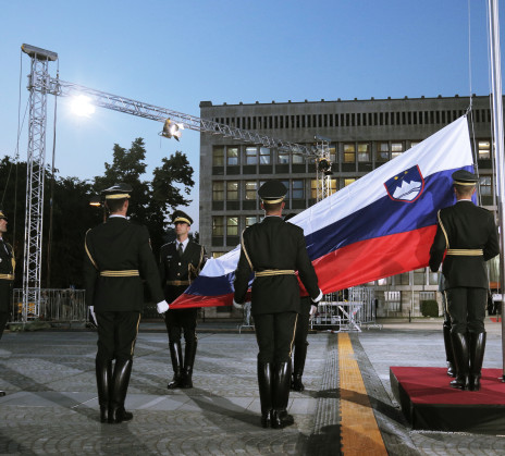 Members of a ceremonial guard take part in raising the Slovenian flag on a flagpole at Republic Square in front of the parliament building.