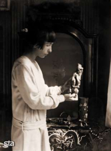 Black and white photograph of Alma holding the statuette.