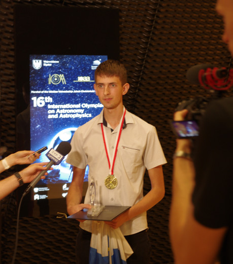 Andolšek, with a gold medal around his neck, answers journalists' questions.