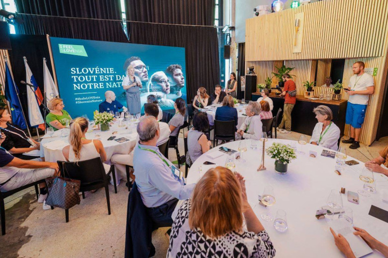 Event participants listen to Ana Roš on stage.