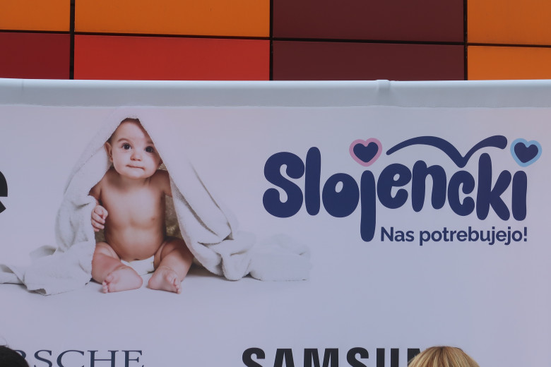 Sign on the billboard: 'The babies need us!