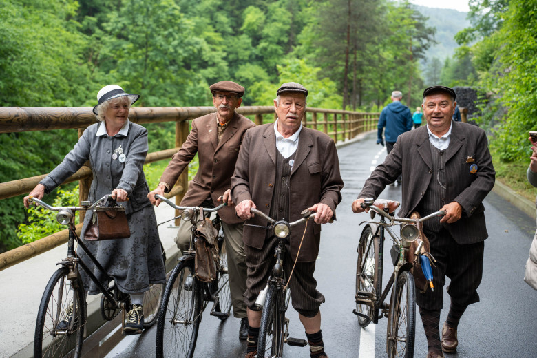Four older cyclists in vintage clothes.