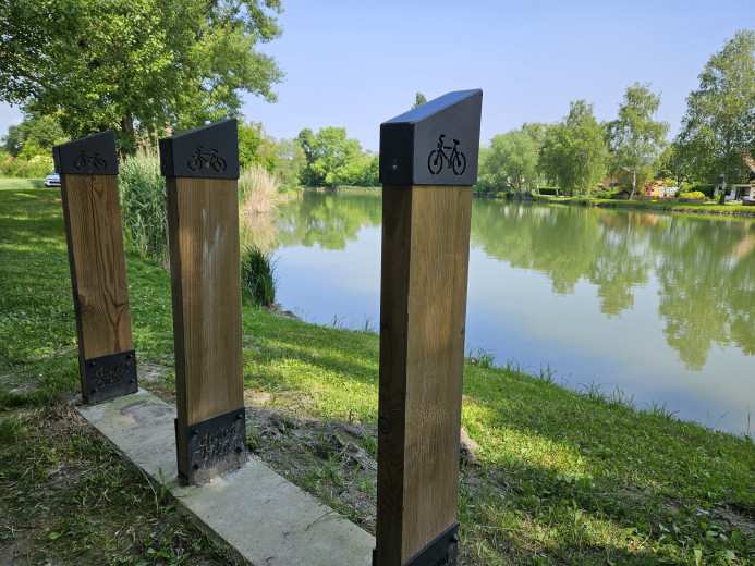Wooden posts marking bicycles along the river.
