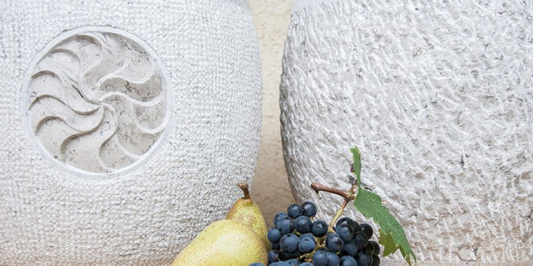 Two stone bowls, with fruit in the foreground.