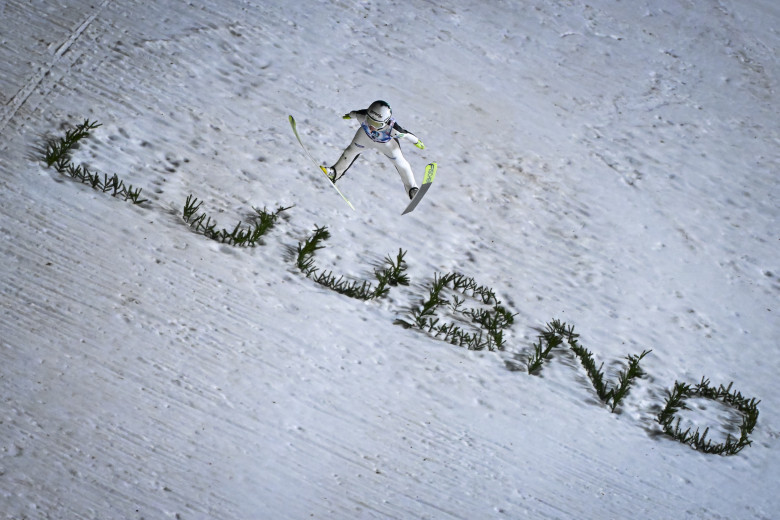 A female jumper in the air above the Ljubno sign.