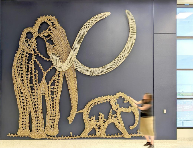 An art installation made of rope in lace technique - a mammoth with a life-size cub.