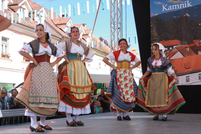 Four women performers in national costumes on stage.