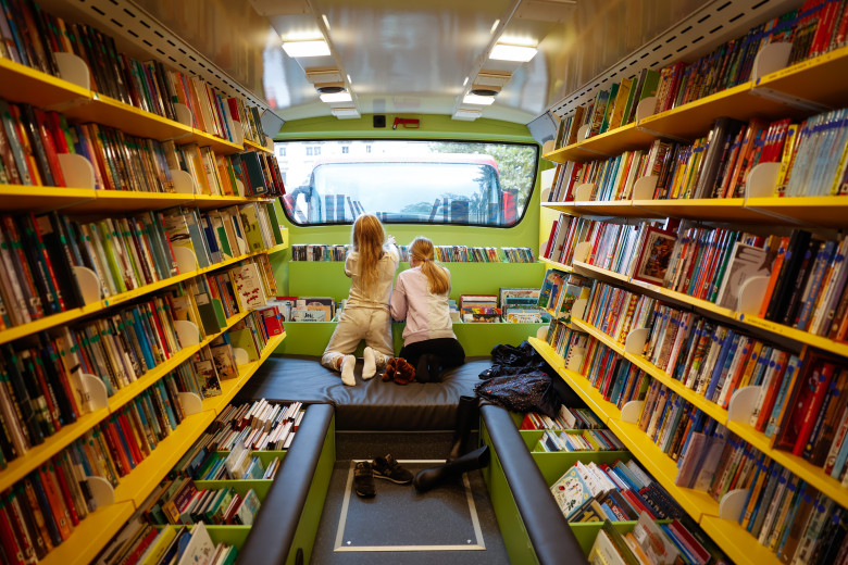 Dve deklici v notranjosti bibliobusa.
