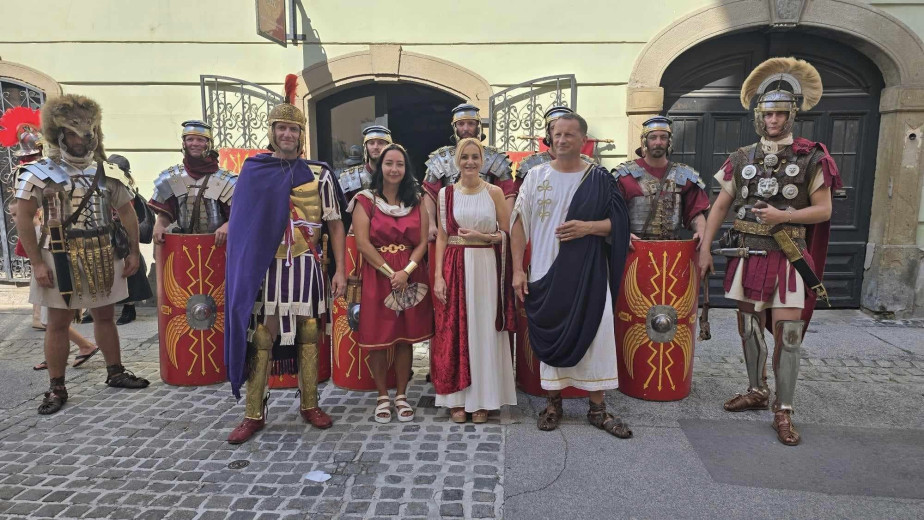 The performers pose in Roman dress.