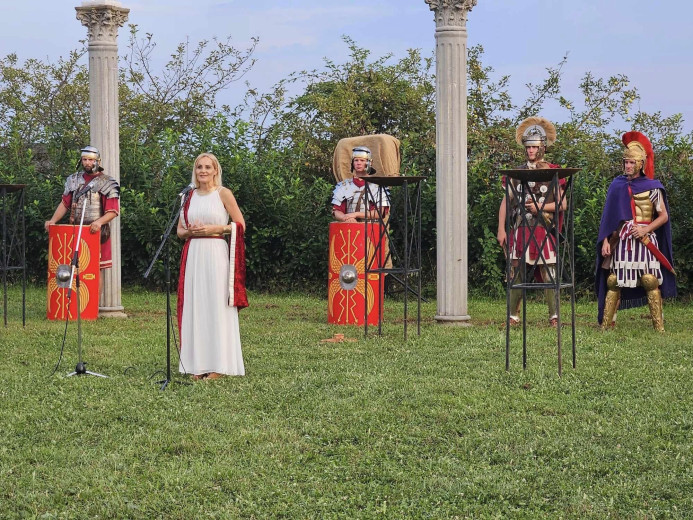 Performers in Roman dress on a meadow.