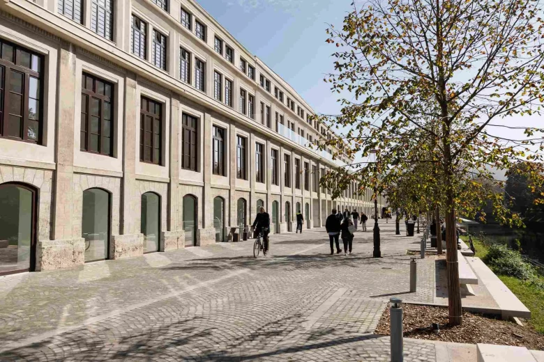 The outside of the building of the Rog Centre, people walking and biking by.