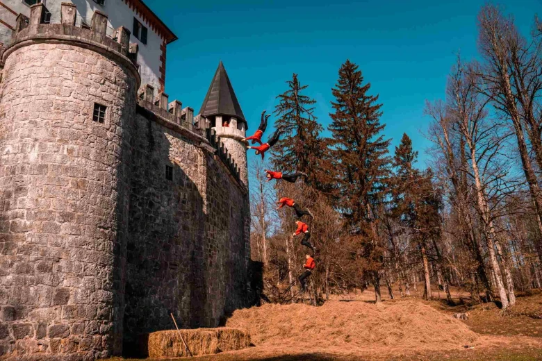  Nekaj ​​​​trenutkov zamrznjenih slik akrobata Dunking Devils, medtem ko skače z grajskega obzidja in dela salto nazaj.