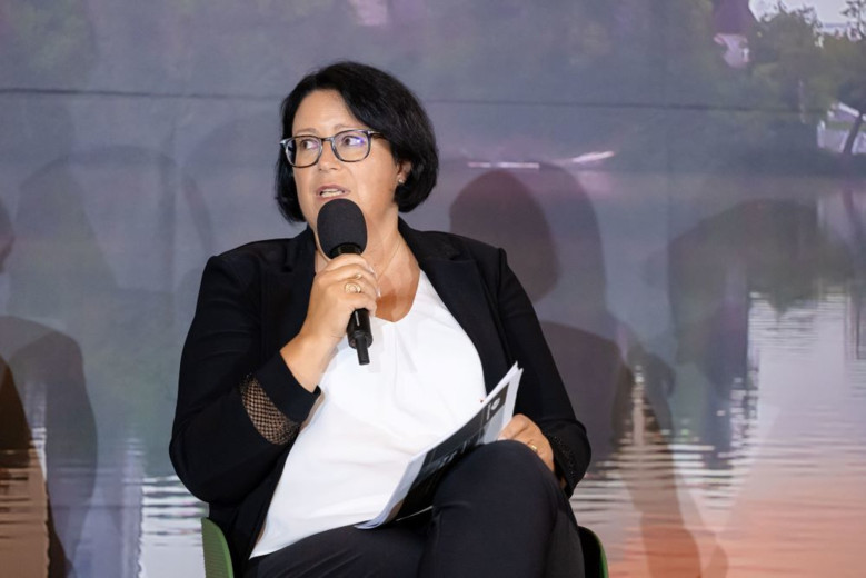 Dubravka Kalin is sitting on a chair, holding a microphone.