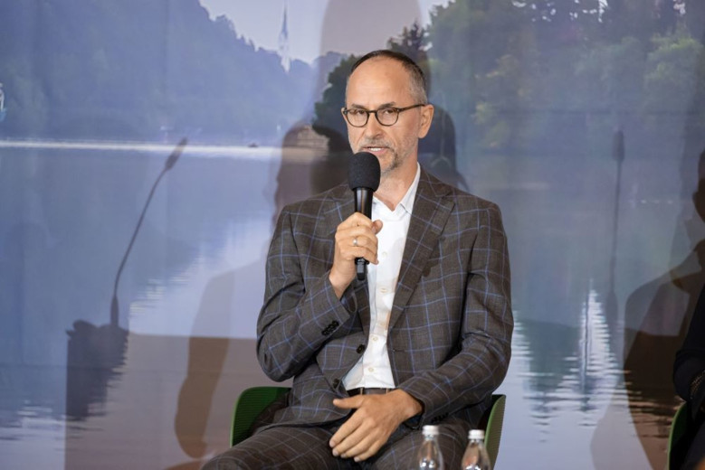 Erwin Hinteregger sits down and speaks into a microphone.