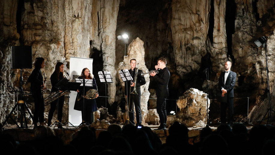 Nastopajoči glasbeniki na odru v jami.