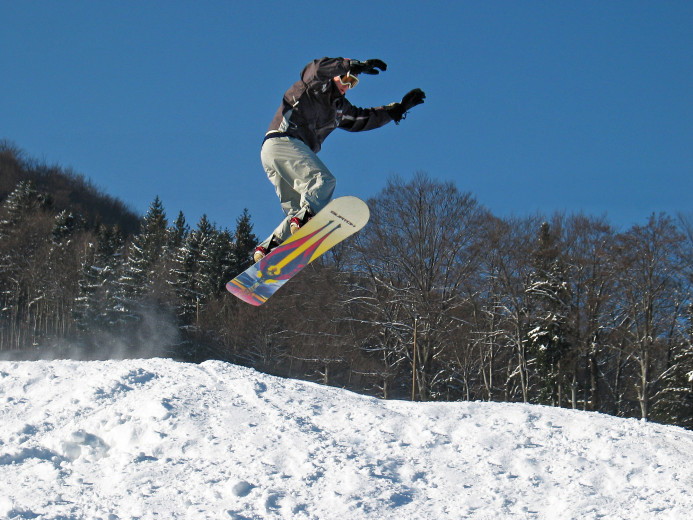 A skier on a board in the air.