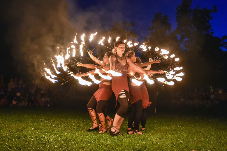 Dancers spin fire torches in a circle.