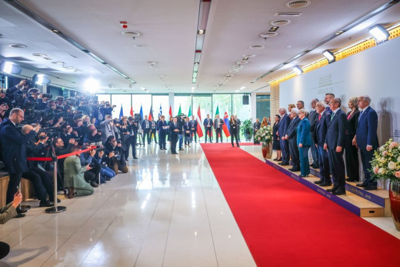 Twelve European presidents, members of the Arraiolos Group, pose on a red carpet before the start of the meeting, while being photographed by a crowd of photographers.