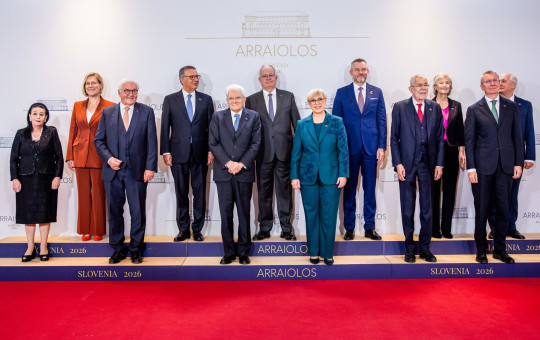 Twelve European presidents, members of the Arraiolos Group, pose in a formal group photo on a red carpet before an “Arraiolos” backdrop.