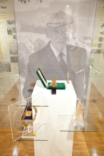 Medals in the foreground, Štukelj's photo in the background.