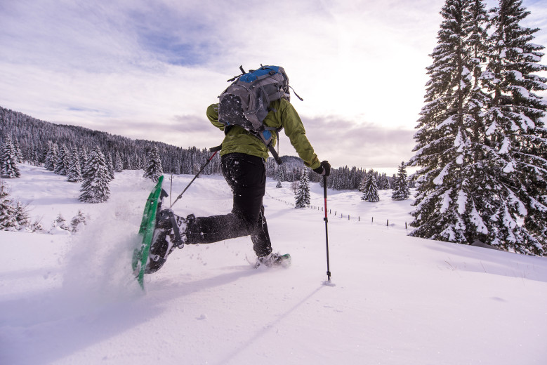 A man walks with snowshoes in Pokljuka.