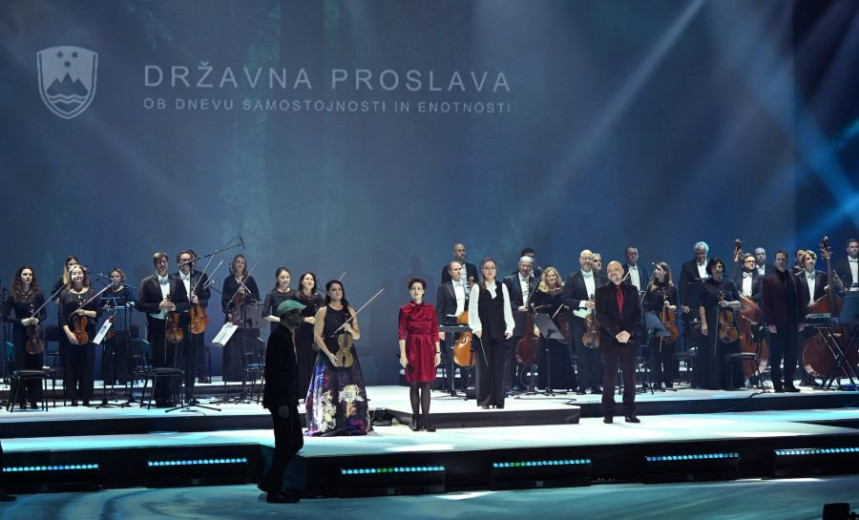 Members of the orchestra staning on a stage.