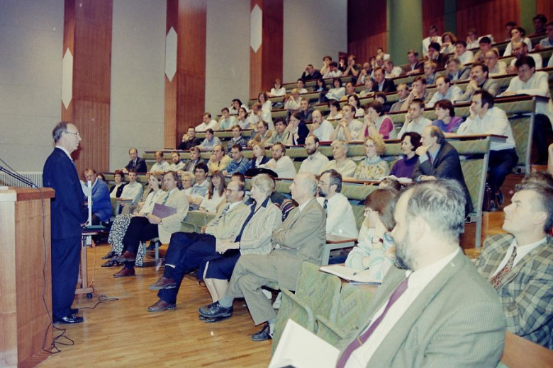 Donald Michie is giving a lecture to a packed lecture hall at the Jožef Stefan Institute.