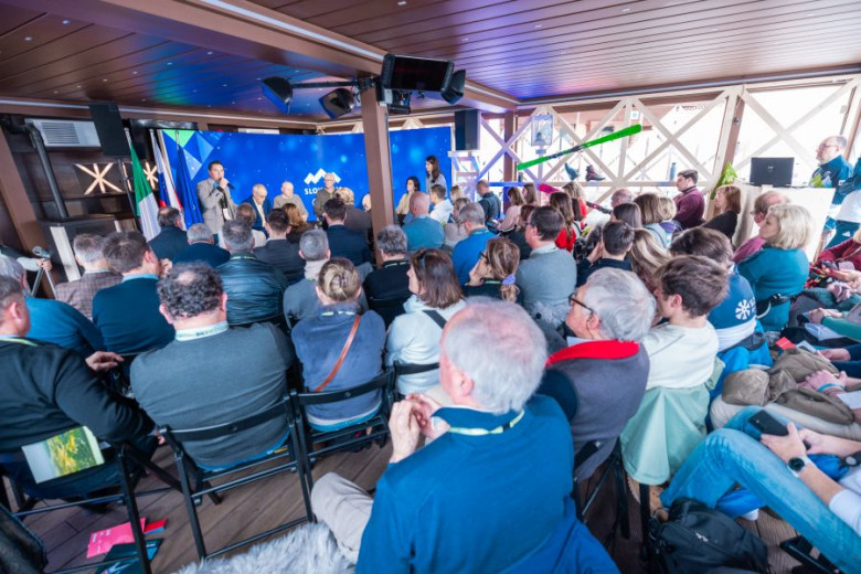 Room full of people sitting and listening the panelists on stage.