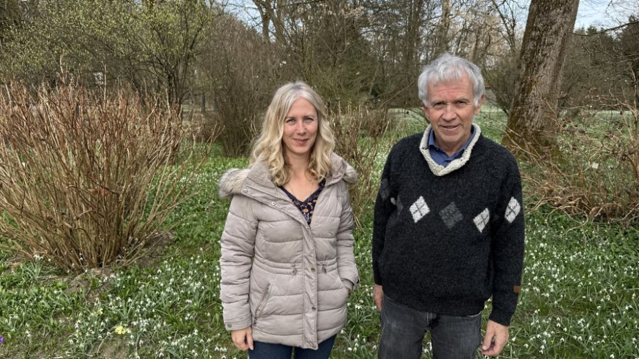 Snowdrops experts dr. Blanka Ravnjak and dr. Jože Bavcon standing in front of a meadow full of snowdrops.